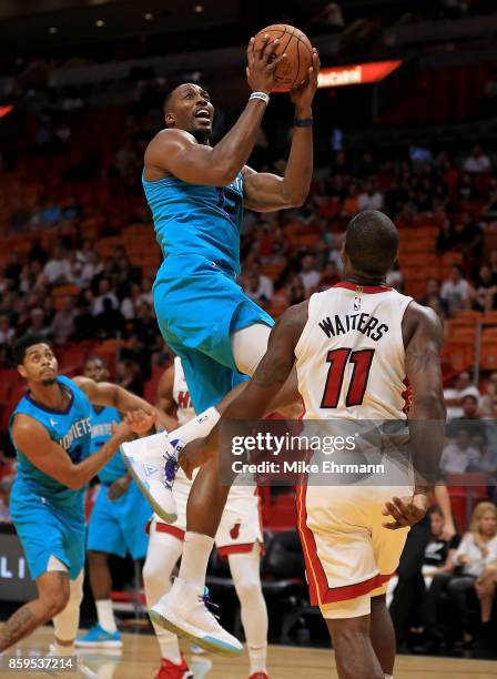 Dwight Howard of the Charlotte Hornets drives to the basket during a preseason game against the Miami Heat at American Airlines Arena on October 9,...