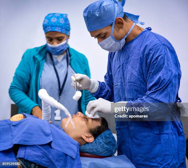 anestesiólogo y ayudante quirúrgico preparación a paciente femenino para procedimiento quirúrgico nariz y liposucción. - intubation fotografías e imágenes de stock