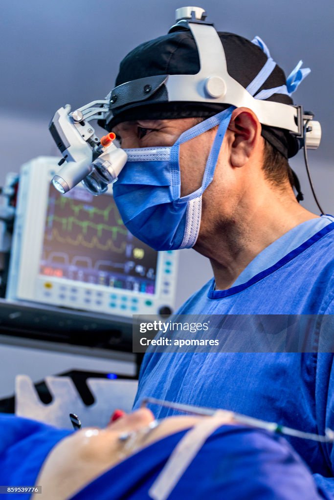 Surgeon and female patience during nasal septun deviation and rhinoplasty surgery.