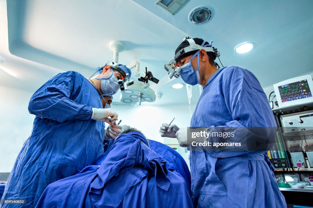 Chirurgiens faisant côtes du cartilage extraction sur femme poitrine patient pour la chirurgie de déviation et rhinoplastie septun nasale.