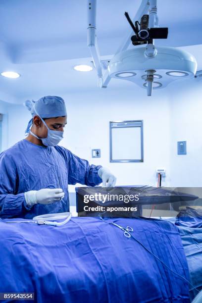 verpleger chirurgische instrumentalist zich klaar voor de procedure in een chirurgische kamer. - weefseltang stockfoto's en -beelden