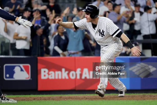 Todd Frazier of the New York Yankees celebrates with his teammates after sliding save to home plate to score on Brett Gardner sacrifice fly to center...