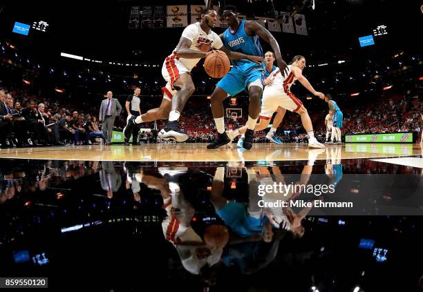 James Johnson of the Miami Heat drives on Johnny O'Bryant III of the Charlotte Hornets during a preseason game at American Airlines Arena on October...