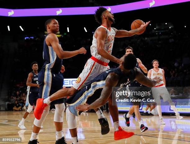 Tyler Dorsey of the Atlanta Hawks drives between Ivan Rabb and Jarell Martin of the Memphis Grizzlies at McCamish Pavilion on October 9, 2017 in...