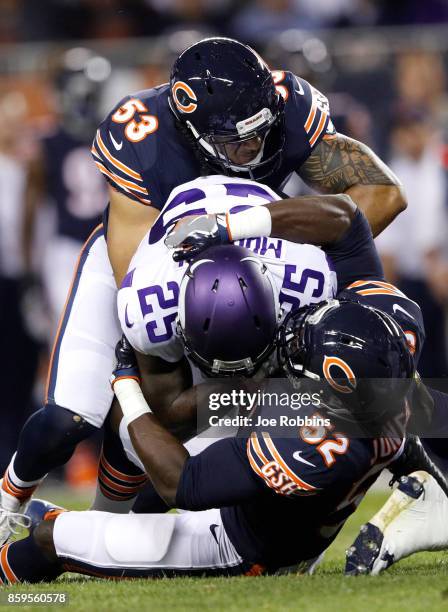 Latavius Murray of the Minnesota Vikings holds onto the football against John Timu and Christian Jones of the Chicago Bears in the first quarter at...