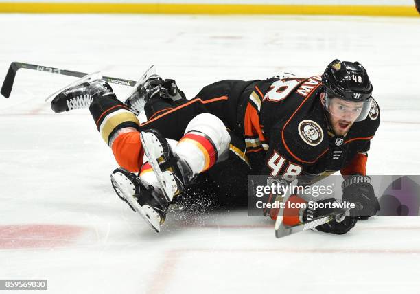 Anaheim Ducks Winger Logan Shaw falls on top of a Calgary player and pins him to the ice during an NHL game between the Calgary Flames and the...