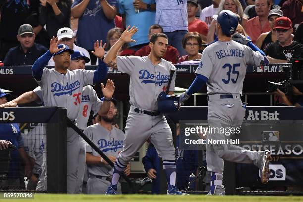 Cody Bellinger of the Los Angeles Dodgers reacts with team mate Austin Barnes and manager Dave Roberts after hitting a one run home run during the...