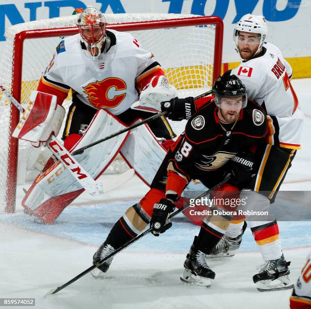 Logan Shaw of the Anaheim Ducks battles in front of the net against T.J. Brodie and Mike Smith of the Calgary Flames during the game on October 9,...