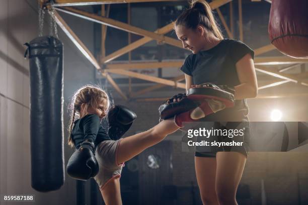 meisje kick boksen met vrouwelijke coach beoefenen. - kids boxing stockfoto's en -beelden