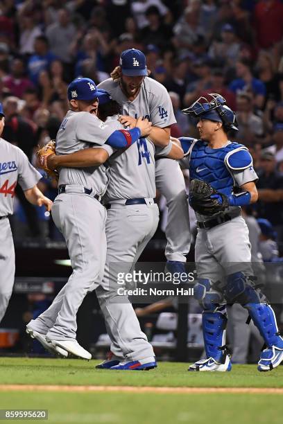 Clayton Kershaw of the Los Angeles Dodgers celebrates with relief pitcher Kenley Jansen and Yasmani Grandal after beating the Arizona Diamondbacks...