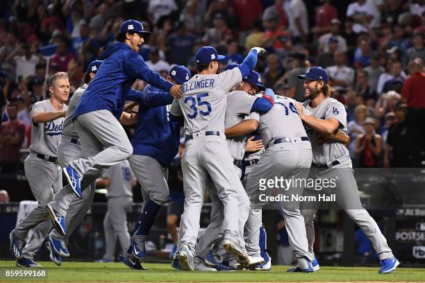 Clayton Kershaw of the Los Angeles Dodgers celebrates with Cody Bellinger and Yu Darvish after beating the Arizona Diamondbacks 3-1 to win the...
