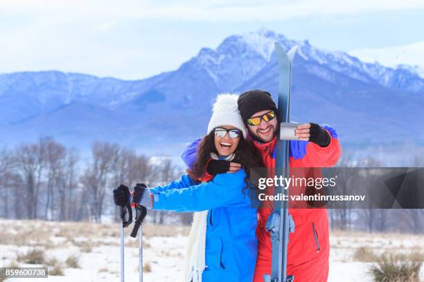 couple skiers taking selfie in snow mountain - knit-hat stock pictures, royalty-free photos & images
