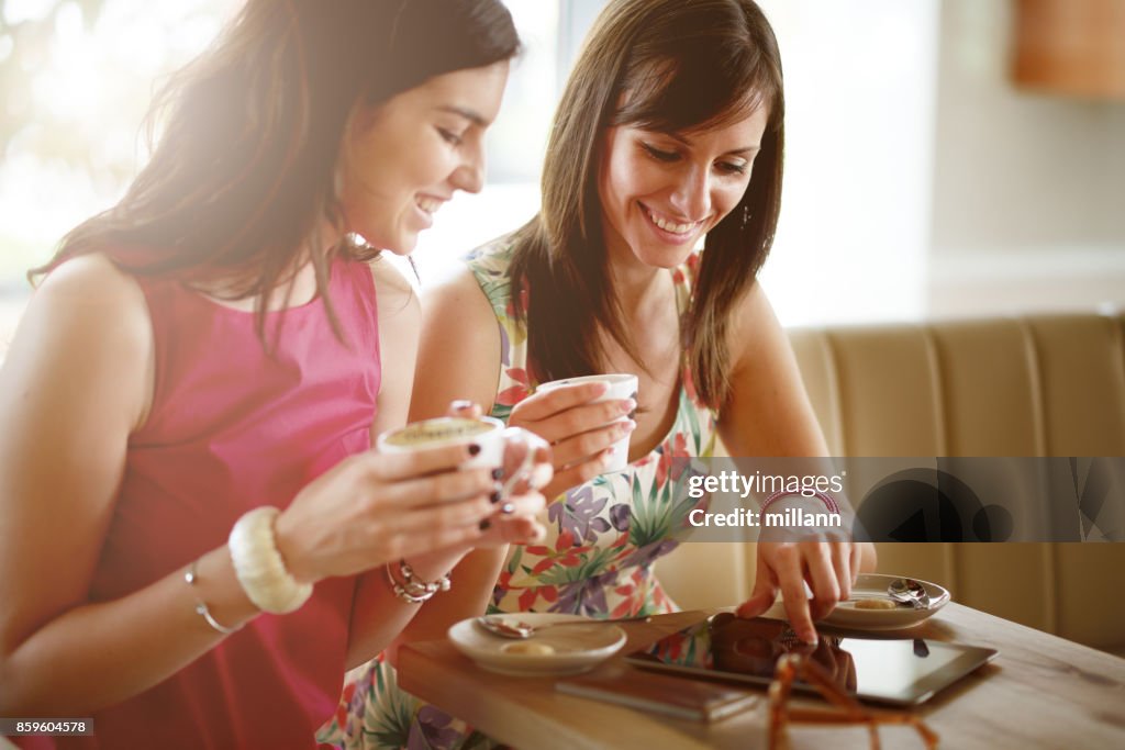 Twee meisjes zitten in Cafe en het gebruik van Tablet PC