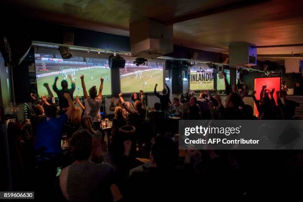 Icelandic football fans react while watching TV their national football team play during the FIFA World Cup 2018 qualification football match against...