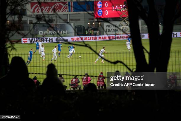 Icelandic football fans who missed out on tickets climb trees and watch between gaps in the fence their national football team play during the FIFA...