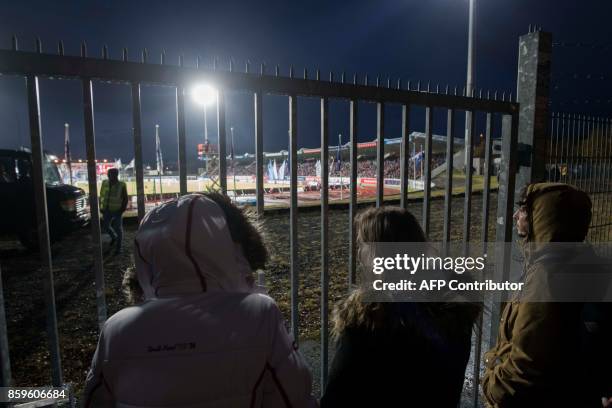 Icelandic football fans who missed out on tickets climb trees and watch between gaps in the fence their national football team play during the FIFA...