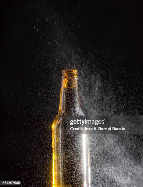 bottle of beer with the glass esmerilado with drops of water and a steam cloud frozen on a black bottom - beer mat stockfoto's en -beelden