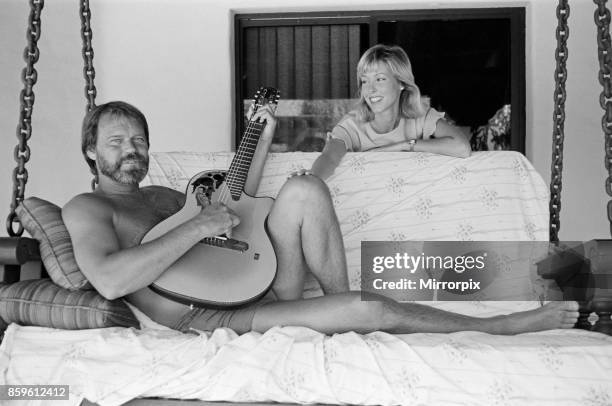 Glen Campbell and his wife to be, Kim Woollen at home in Phoenix, Arizona, USA. Glen serenades Kim, singing songs with his guitar, by the swimming...