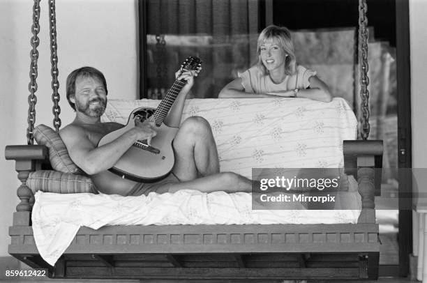 Glen Campbell and his wife to be, Kim Woollen at home in Phoenix, Arizona, USA. Glen serenades Kim, singing songs with his guitar, by the swimming...