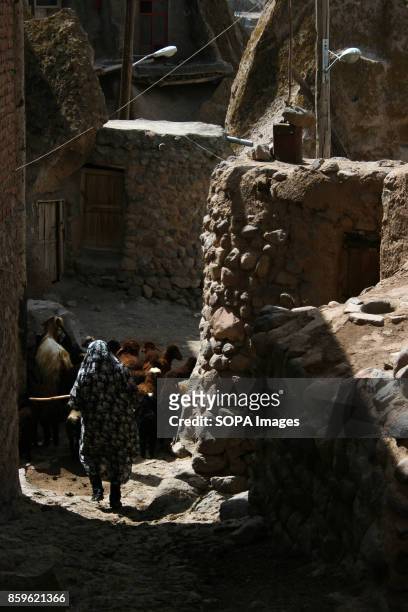 Local woman is pictured as she walks through the narrow alley inside the village. The tiny village of Kandovan , in the Iranian East Azerbaijan...