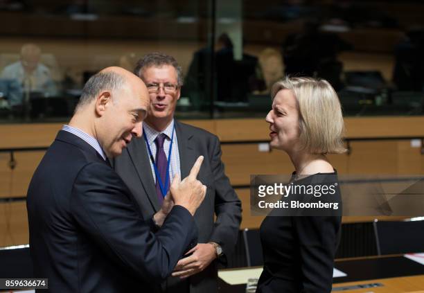 Pierre Moscovici, economic commissioner for the European Union , left, gestures while speaking with Liz Truss, chief secretary to the U.K. Treasury,...