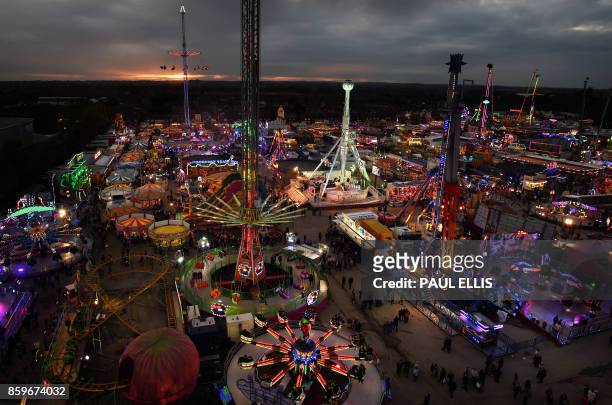 Visitors attend the 'Hull Fair', one of Europe's largest annual travelling fairs, in Hull, north east England on October 9, 2017. - Showmen and women...
