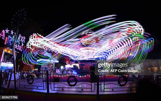 Visitors attend the 'Hull Fair', one of Europe's largest annual travelling fairs, in Hull, north east England on October 9, 2017. Showmen and women...