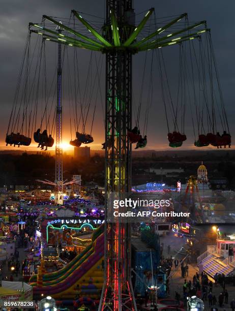 Visitors attend the 'Hull Fair', one of Europe's largest annual travelling fairs, in Hull, north east England on October 9, 2017. Showmen and women...