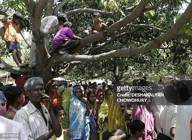 Villagers wait for Indian External Affairs Minister and senior Congress leader Pranab Mukherjee on a mango farm during an election roadshow in...
