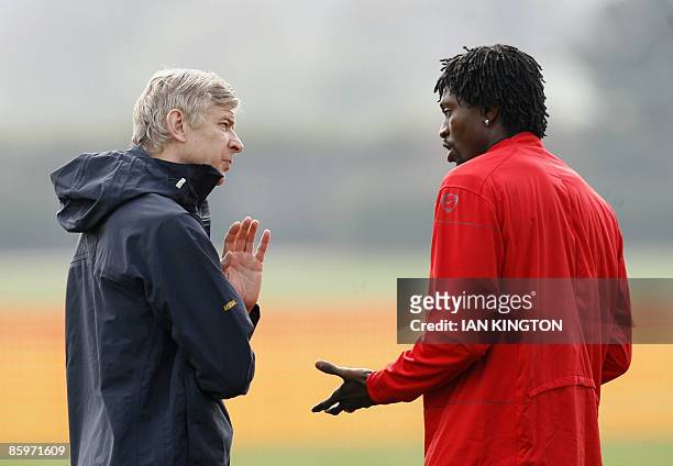 Arsene Wenger, manager of Arsenal, talks to Arsenal's Togolese player Emmanuel Adebayor during a training session at Arsenal's training facility in...