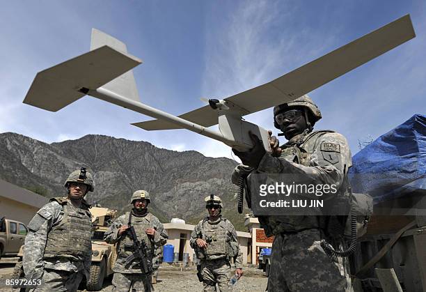 Soldier from 1st Infantry Division prepares an RQ-11 Raven miniature unmanned aerial vehicle during a mission to search for weapons caches at Alaugal...