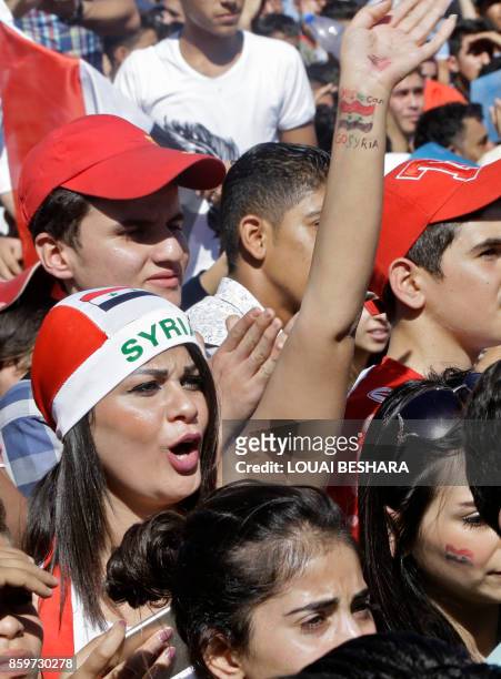 Syrians cheer on their national team at the Umayyad Square in Damascus as they watch a live broadcast of the World Cup qualifying play-off football...
