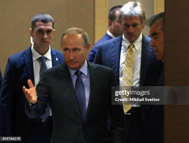 Russian President Vladimir Putin gestures as Tajik President Emomali Rakhmon looks on during their meeting on October 11, 2017 in Sochi, Russia....