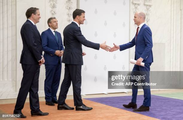 Gert-Jan Segers of the ChristenUnie shakes hands with Dutch Prime Minister Mark Rutte of the People's Party for Freedom and Democracy , next to...