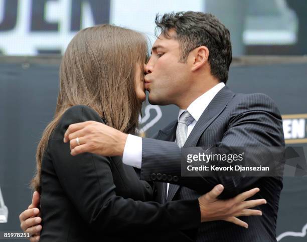 Boxer Oscar De La Hoya kisses his wife Millie Corretjer after announcing his retirement from boxing on April 14, 2009 at Staples Center in Los...