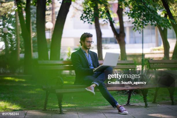 fühlt sich gut an nicht im büro sein - bench park stock-fotos und bilder