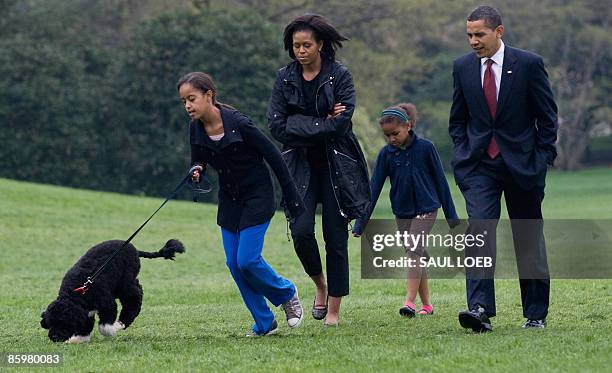 Malia Obama walks her new six-month old Portuguese water dog Bo alongside US President Barack Obama, Sasha Obama and First Lady Michelle Obama on the...