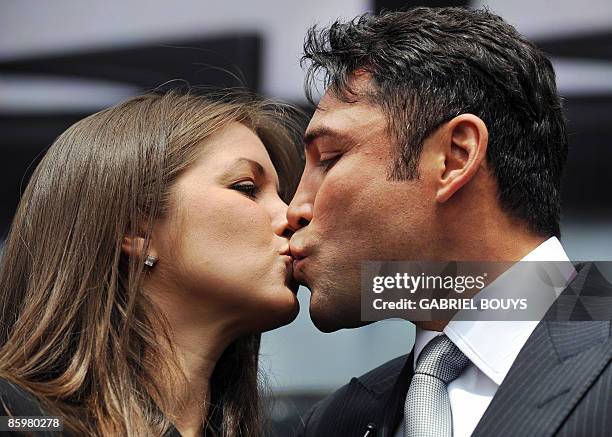 Oscar De La Hoya kisses his wife Millie Corretjer after announcing his retirement from boxing during a press conference in Los Angeles on Tuesday,...