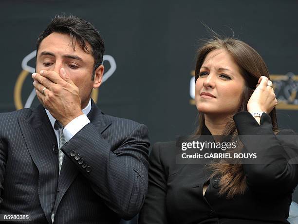 Oscar De La Hoya reacts beside his wife Millie Corretjer after announcing his retirement from boxing during a press conference in Los Angeles on...