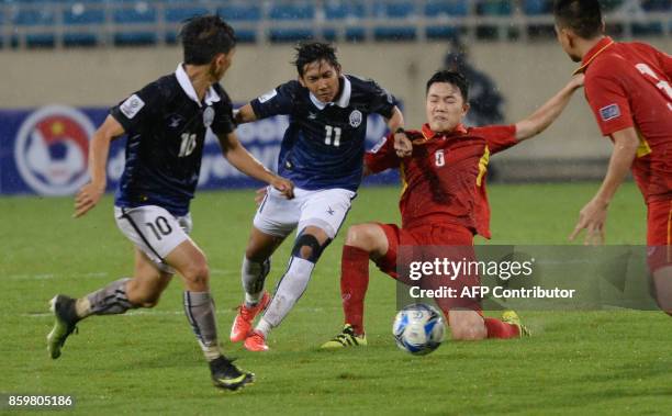 Vietnam's Luong Xuan Truong fights for the ball with Cambodia's Chan Vathanaka and Keo Sokpheng during the AFC Asian 2019 Cup qualifier against...