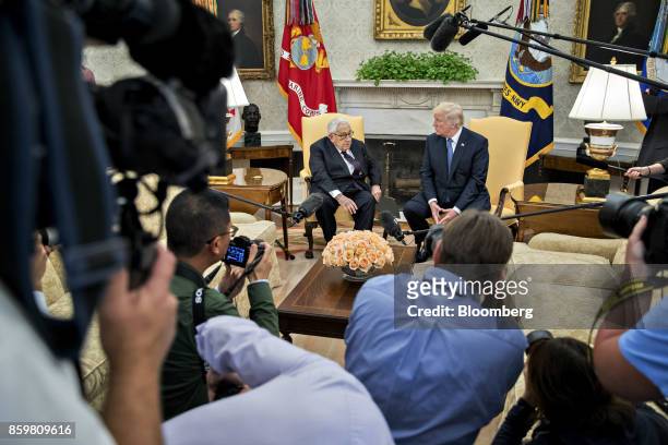 President Donald Trump, right, listens as Henry Kissinger, former U.S. Secretary of state, speaks during a meeting in the Oval Office of the White...