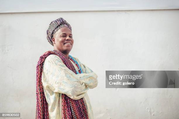 afro-brazilian man in traditional religious costume in front of wall - citizenship ceremony stock pictures, royalty-free photos & images