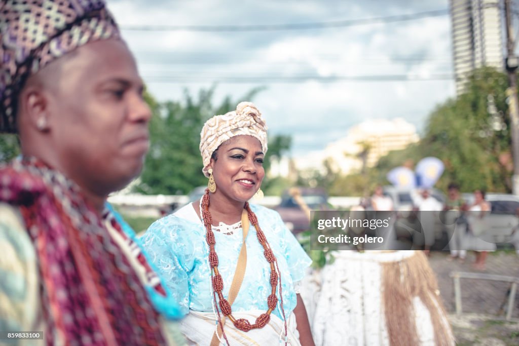 Baiana and baiano in traditional costume doing religious ceremony in Salvador