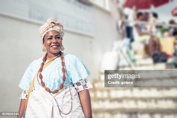 sorrindo baiana no tradicional traje colorido em frente a igreja em salvador - bahia - fotografias e filmes do acervo