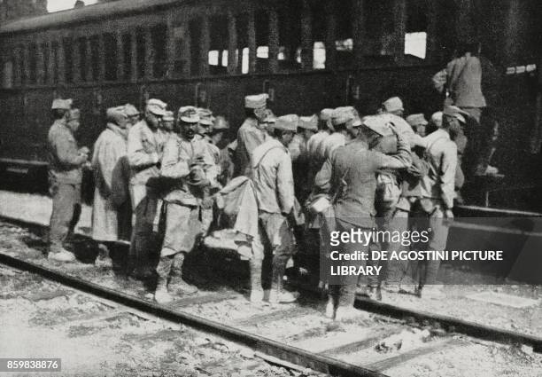 Austrian prisoners captured in the Karst mounting on a railway wagon, Italy, World War I, from L'Illustrazione Italiana, Year XLII, No 47, November...