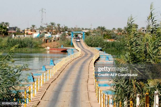 Car crosses a floating bridge across the Tigris River in the town of Dhuluiya, some 90 kilometres north of Baghdad in the Salah ad-Din governorate,...