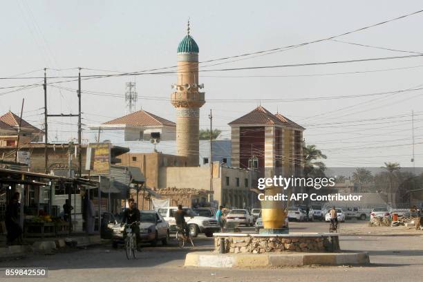 Iraqis ride bicycles in the town of Dhuluiya, some 90 kilometres north of Baghdad in the Salah ad-Din governorate, on October 10, 2017. / AFP PHOTO /...