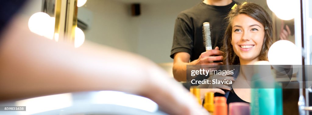 Lächelnde junge Frau, die immer neue Frisur in den Friseursalon