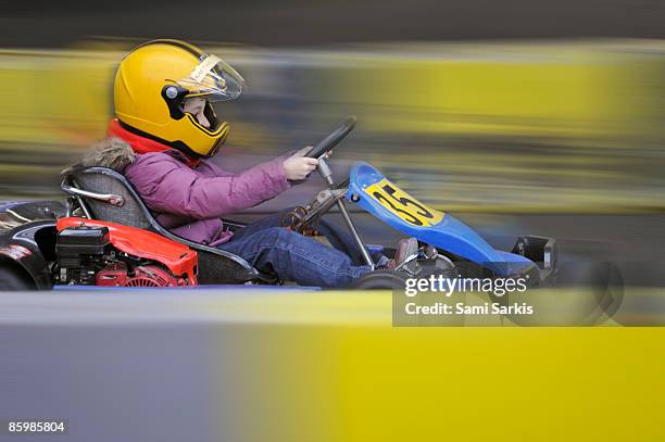 girl (9) driving a go-cart on a race track - helmet cart foto e immagini stock