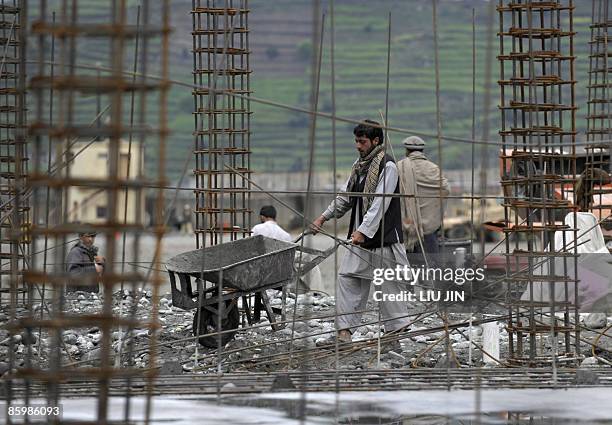 An Afghan man works on a construction site at ISAF's Camp Bostick in Naray, in Afghanistan's eastern Kunar province on April 15, 2009. United States...